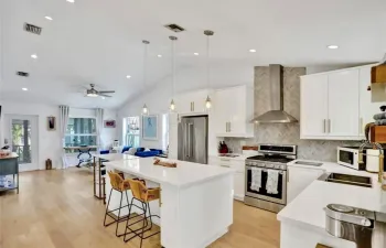 Open concept kitchen with a quartz countertop island. Stainless steel appliances.